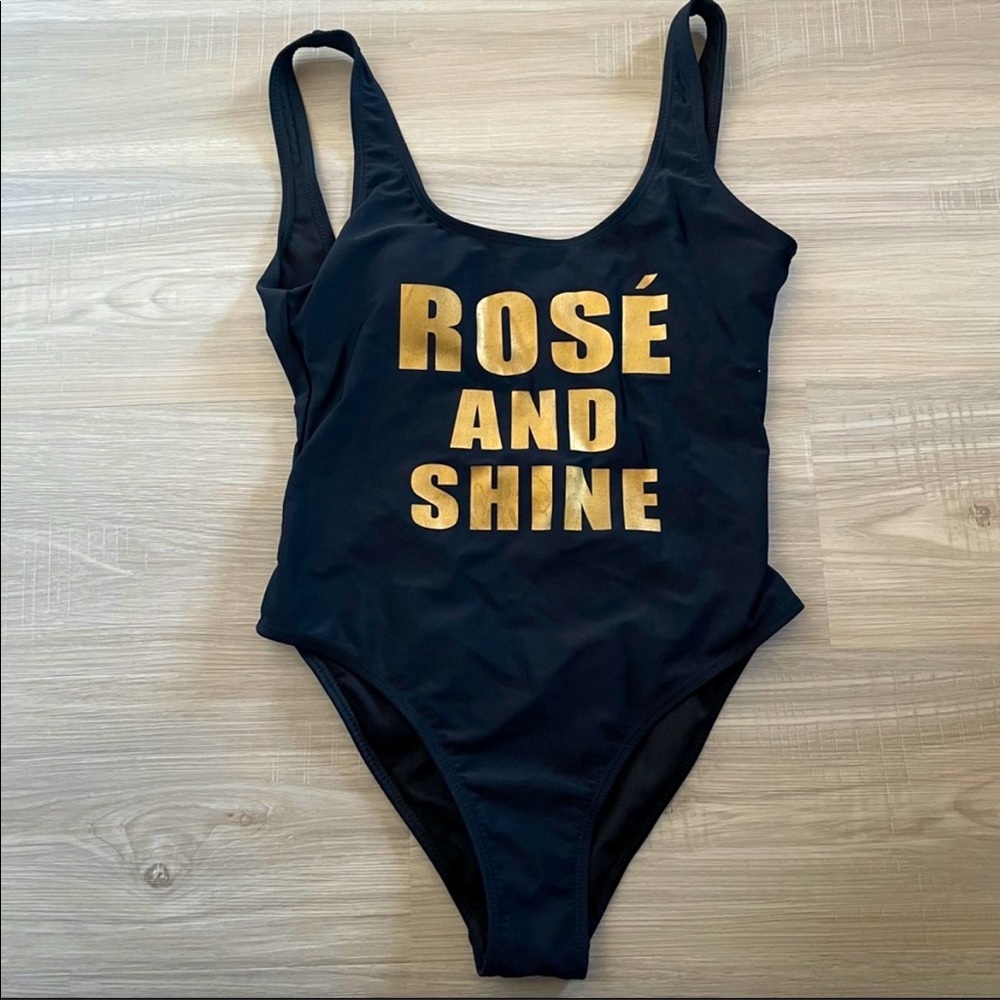 NWT black one piece swimsuit with gold lettering ‘Rose and Shine’. Small.